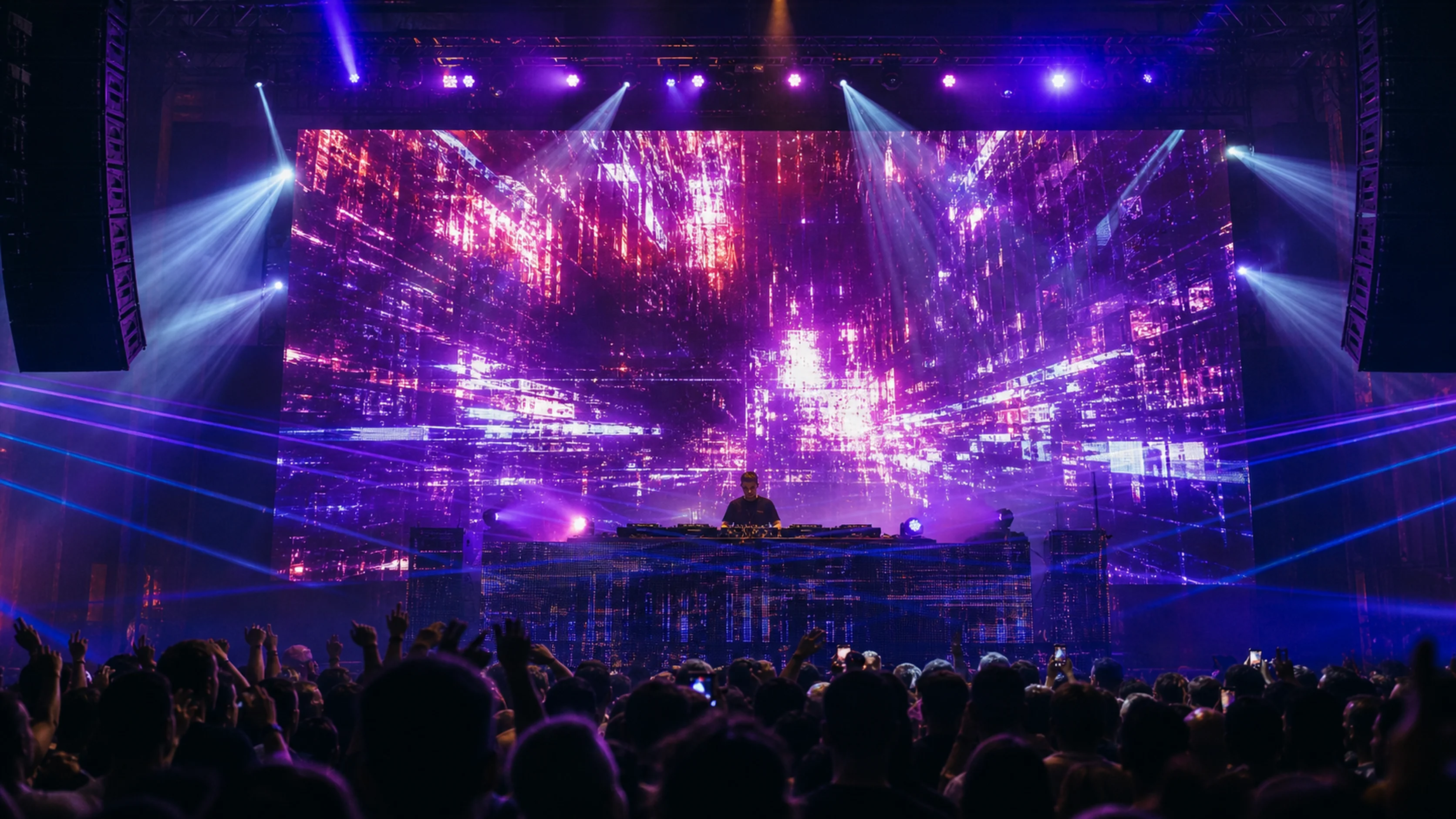 Main stage front view — performer silhouette against a massive LED wall with magenta and violet visuals, lasers, hands-up crowd